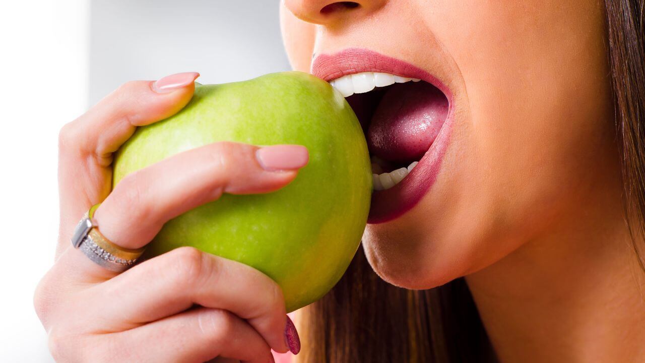 Girl eating green apple 